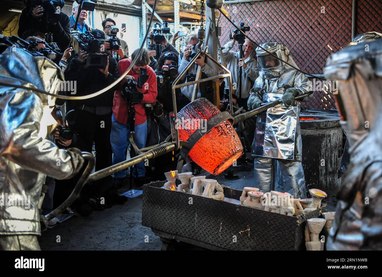 BURBANK, Jan. 13, 2015 -- Workers pour molten bronze into molds during a media event to display the production of the bronze statuette awards for the 21st annual Screen Actors Guild (SAG) Awards in Burbank, California, the United States, on Jan 13, 2015. The statuette, known as The Actor , was originally designed by Jim Heimann and Jim Barrett, and sculpted by Edward Saenz. It is 16 inches (40.6 cm) tall and weighs 12 pounds (5.4 kg). Since the 1st SAG Awards in 1995, the awards have been produced by the American Fine Arts Foundry in Burbank. The 21st SAG Award ceremony will be held in Los Ang Stock Photo