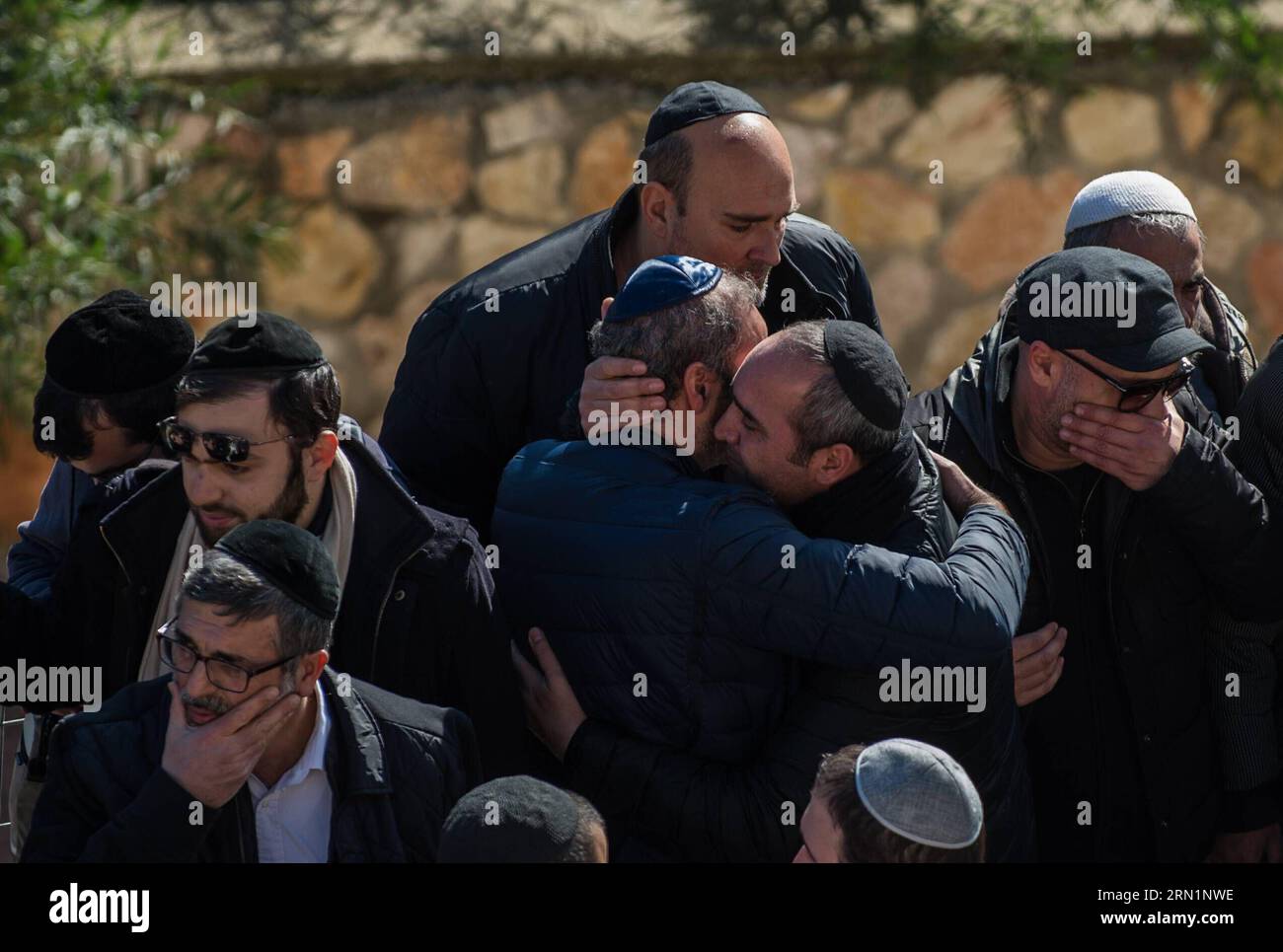 (150113) -- JERUSALEM, Jan. 13, 2015 -- People embrace each other during a funeral ceremony for the four victims of Paris supermarket attack at Givat Shaul cemetery, on the outskirts of Jerusalem, on Jan. 13, 2015. Israeli leaders and multitude of mourners gathered Tuesday with the families of four Jewish victims of last week s terror attack on a Paris kosher supermarket for a solemn funeral ceremony at a Jerusalem cemetery. Yoav Hattab, Yohan Cohen, Philippe Braham and Francois-Michel Saada, were gunned down on Friday during a hostage attack on Hyper Casher supermarket in eastern Paris. They Stock Photo