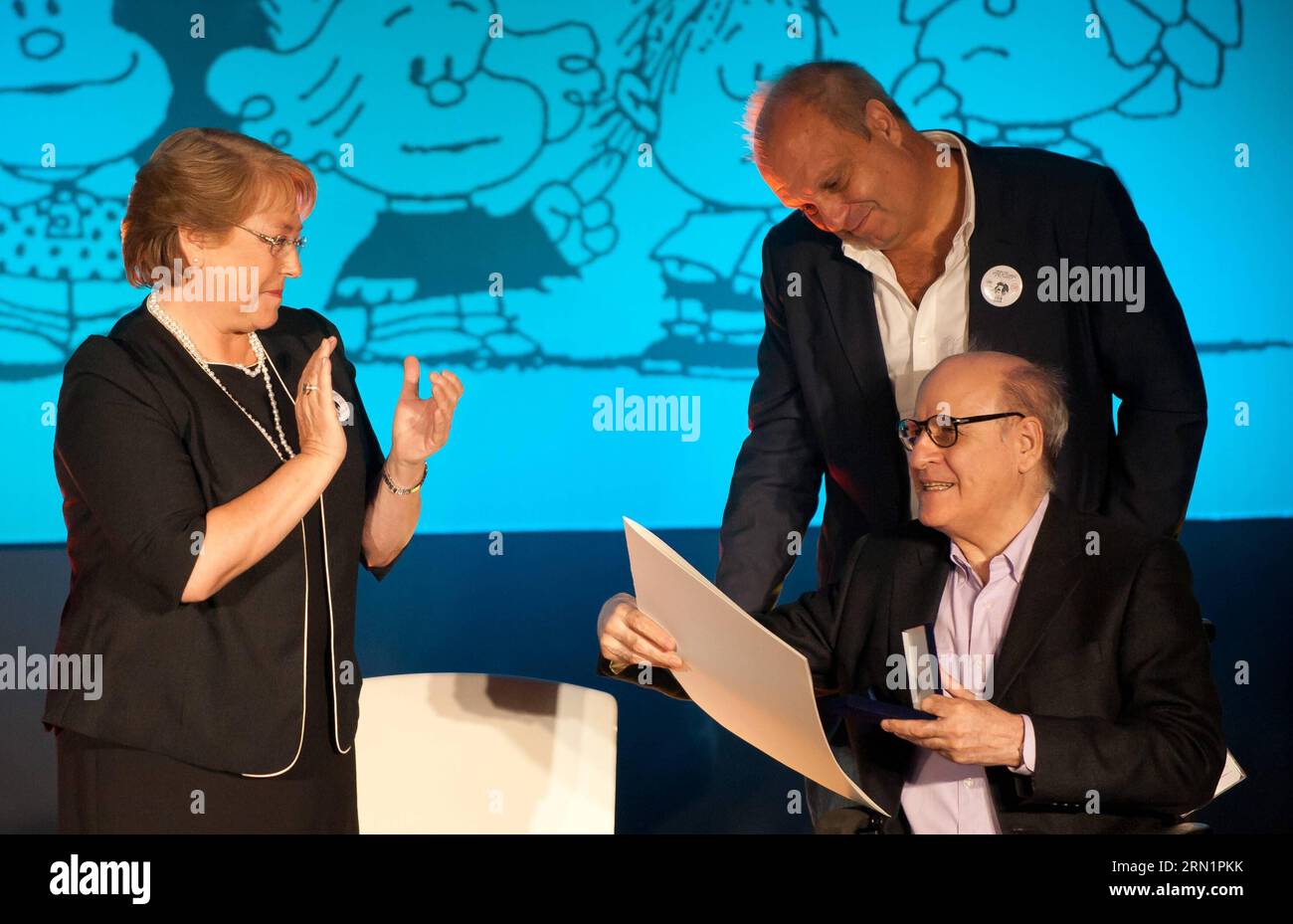 150115 -- SANTIAGO, Jan. 15, 2015 -- Chile s President Michelle Bachelet L, hands over the Order of Artistic and Cultural Merit Pablo Neruda , to Argentine cartoonist Joaquin Salvador Lavado Tejon, better known as Quino R, front, at Gabriela Mistral Cultural Center, in Santiago, capital of Chile, on Jan. 15, 2015. Jorge Villegas jg CHILE-SANTIAGO-ARGENTINA-CULTURE-QUINO e JORGExVILLEGAS PUBLICATIONxNOTxINxCHN Stock Photo