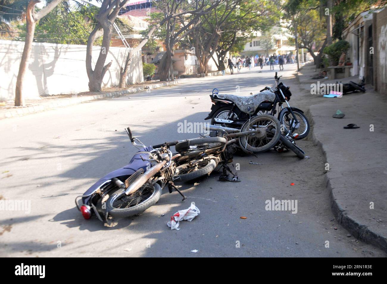 (150116) -- KARACHI, Jan. 16, 2015 -- Damaged motorbikes are seen as activists of the Jamaat-e-Islami religious party throw stones toward riot police near the French consulate during a protest against the printing of satirical sketches of the Prophet Muhammad by French magazine Charlie Hebdo in southern Pakistani port city of Karachi on Jan. 16, 2015.At least six people were injured on Friday afternoon in clashes between police and protesters as the latter marched toward the French Consulate against the printing of blasphemous caricatures by French journal Charlie Hebdo in Pakistan s southern Stock Photo