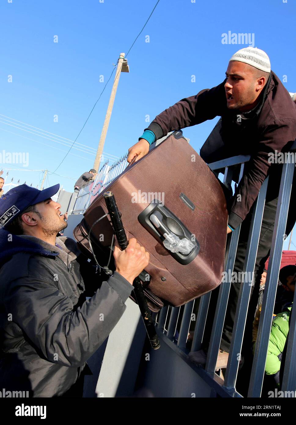 (150120) -- GAZA, Jan. 20, 2015 -- A Palestinian, hoping to cross into Egypt, climb a wall and lower his suitcase at the Rafah crossing between Egypt and the southern Gaza Strip, Jan. 20, 2015. Egyptian authorities reopened Rafah crossing on Tuesday for three days, officials said. Egypt shut the crossing over violence with Islamist militants in Sinai region last October. Since then, it opened the crossing partially to allow thousands of Palestinians to travel in and out of Gaza Strip.Khaled Omar) MIDEAST-GAZA-RAFAH-CROSSING EmadxDrimly PUBLICATIONxNOTxINxCHN   Gaza Jan 20 2015 a PALESTINIAN ho Stock Photo