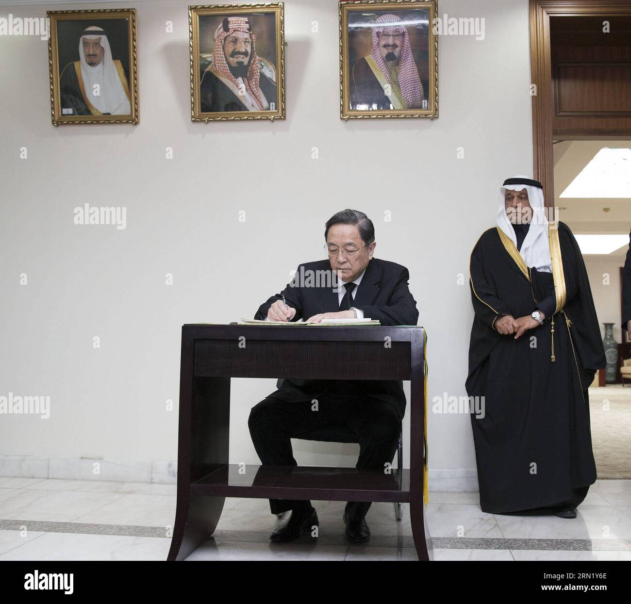 Yu Zhengsheng (L), chairman of the National Committee of the Chinese People s Political Consultative Conference (CPPCC), writes on a condolence book at the embassy of Saudi Arabia in Beijing, capital of China, Jan. 26, 2015. Yu Zhengsheng visited the embassy of Saudi Arabia in Beijing Monday morning to express condolences over the death of King Abdullah bin Abdulaziz. ) (yxb) CHINA-BEIJING-YU ZHENGSHENG-LATE SAUDI KING-MOURNING (CN) HuangxJingwen PUBLICATIONxNOTxINxCHN   Yu Zheng Sheng l Chairman of The National Committee of The Chinese Celebrities S Political Consultative Conference CPPCC wri Stock Photo