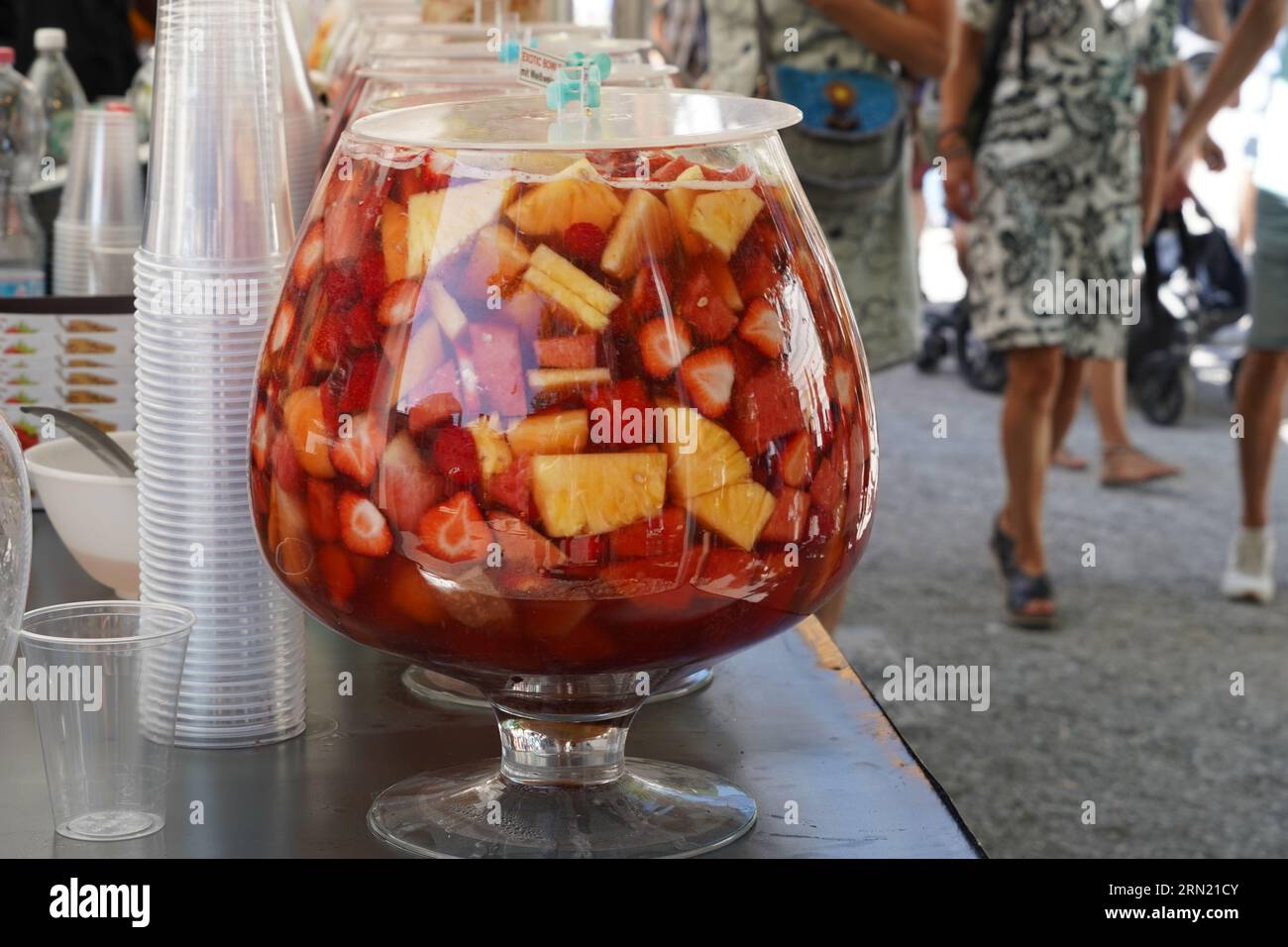 Market stand with punch drinks. Row of serving bowls full of punch with