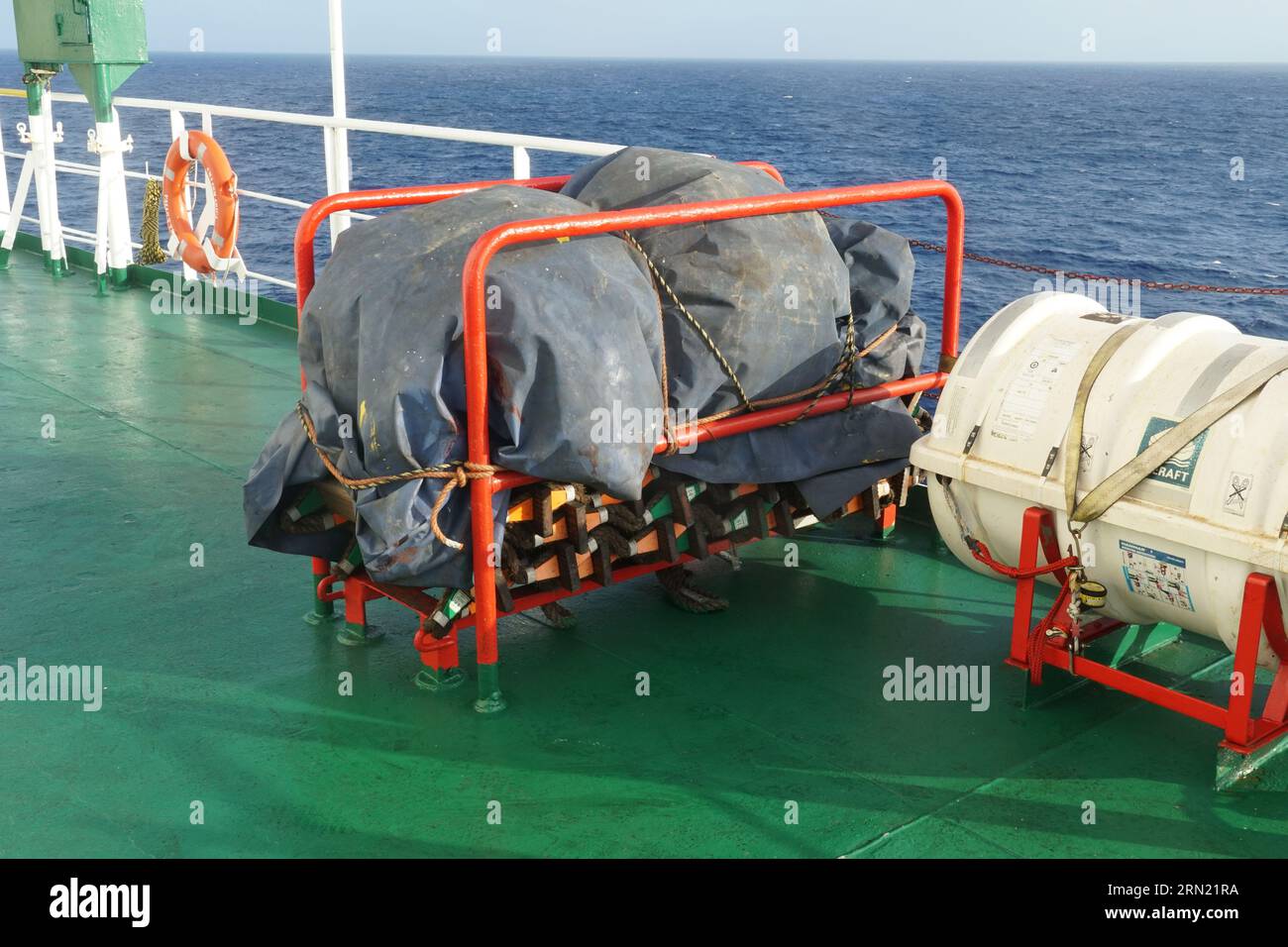 White life raft and embarkation ladder on deck of container ship ready