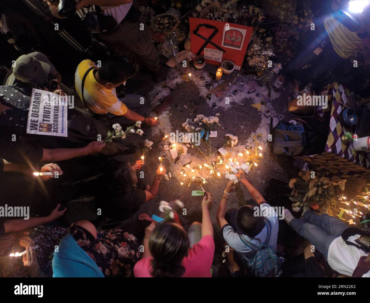 (150203) -- QUEZON CITY, Feb. 3, 2015 -- People light candles and offer flowers and prayers for the slain 49 members of the Philippine National Police Special Action Force (PNP-SAF) at the gate of the PNP Headquarters in Quezon City, the Philippines, Feb. 3, 2015. There was lack of coordination and planning between the military forces and the leadership of the PNP-SAF during the violent clash in Mamasapano, Maguindanao on Jan. 25, chief of the Armed Forces of the Philippines said on Tuesday. ) (lmz) PHILIPPINES-QUEZON CITY-CANDLE LIGHTING RouellexUmali PUBLICATIONxNOTxINxCHN   Quezon City Feb Stock Photo