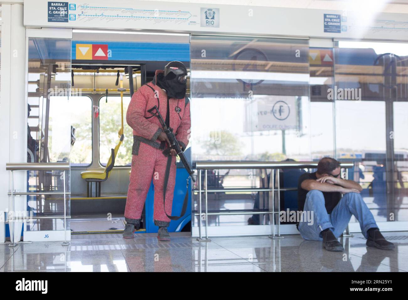 (150211) -- RIO DE JANEIRO, Feb. 11, 2015 -- A simulated terrorist (L) detains a hostage during an anti-terrorism rehearsal at the Golfe Olimpico BRT station in Rio de Janeiro, Brazil, Feb. 11, 2015. An anti-terrorism rehearsal was held here targeting the possible hostage crisis during the Olympic Games on Wednesday. During the rehearsal, the Tactical Intervention Unit (ITU) of Special Police Operations Battalion (BOPE) came to the rescue of the detained hostages in a BRT bus near the Olympic Golf course. This training was part of the BOPE s preparation for the Olympic Games and other similar Stock Photo