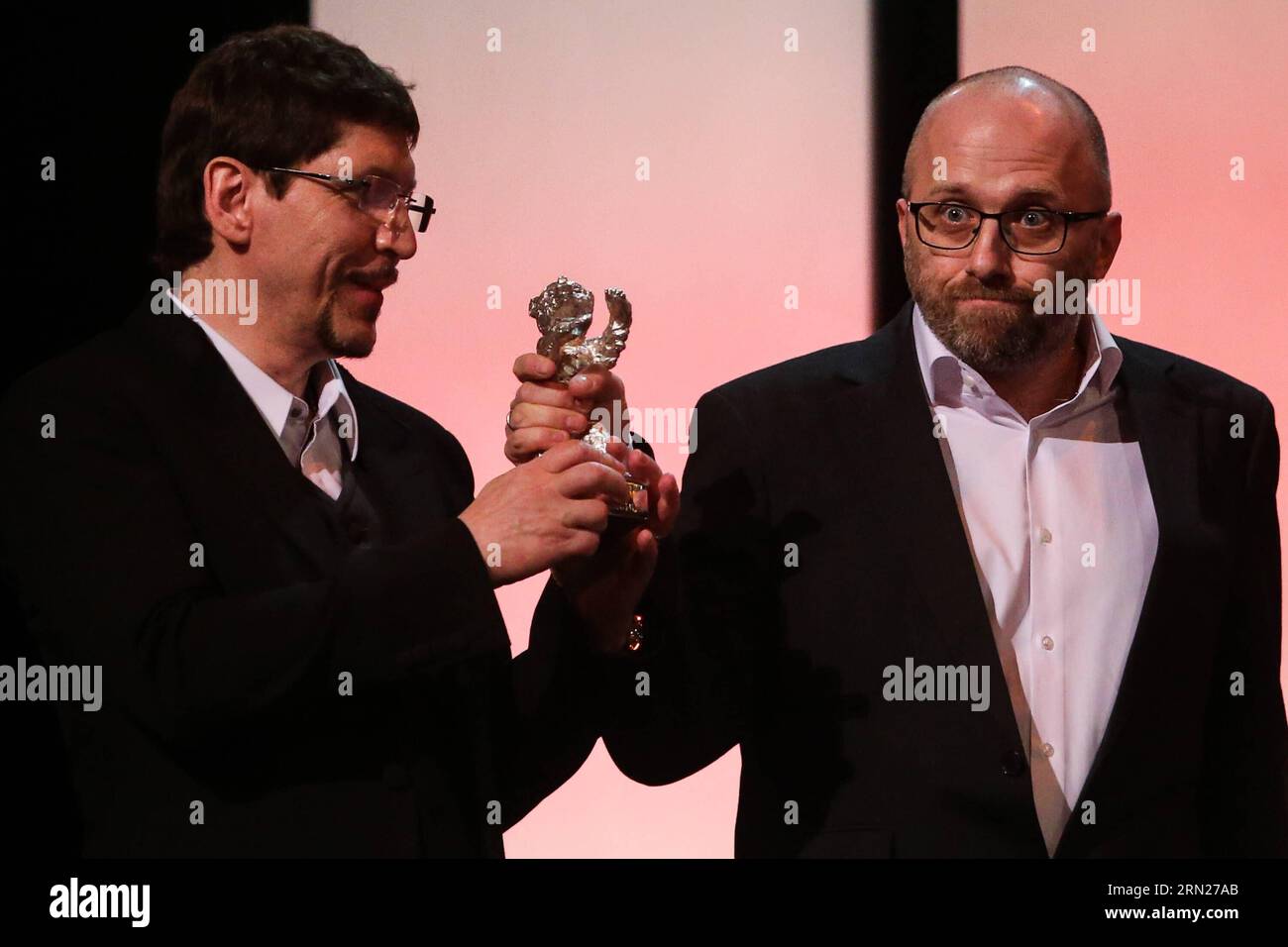 ENTERTAINMENT RED CARPET 65. Berlinale - Preisverleihung (150214) -- BERLIN, Feb. 14, 2015 -- Evgeniy Privin (R) and Sergey Mikhalchuk hold the Silver Bear for an Outstanding Artistic Contribution for the camera for the film Under Electric Clouds during the award ceremony at the 65th Berlinale International Film Festival in Berlin, Germany, Feb. 14, 2015. ) GERMANY-BERLIN-INTERNATIONAL FILM FESTIVAL ZhangxFan PUBLICATIONxNOTxINxCHN   Entertainment Red Carpet 65 Berlinale Award ceremony  Berlin Feb 14 2015 Evgeniy  r and Sergey Mikhalchuk Hold The Silver Bear for to Outstanding ARTISTIC Contrib Stock Photo