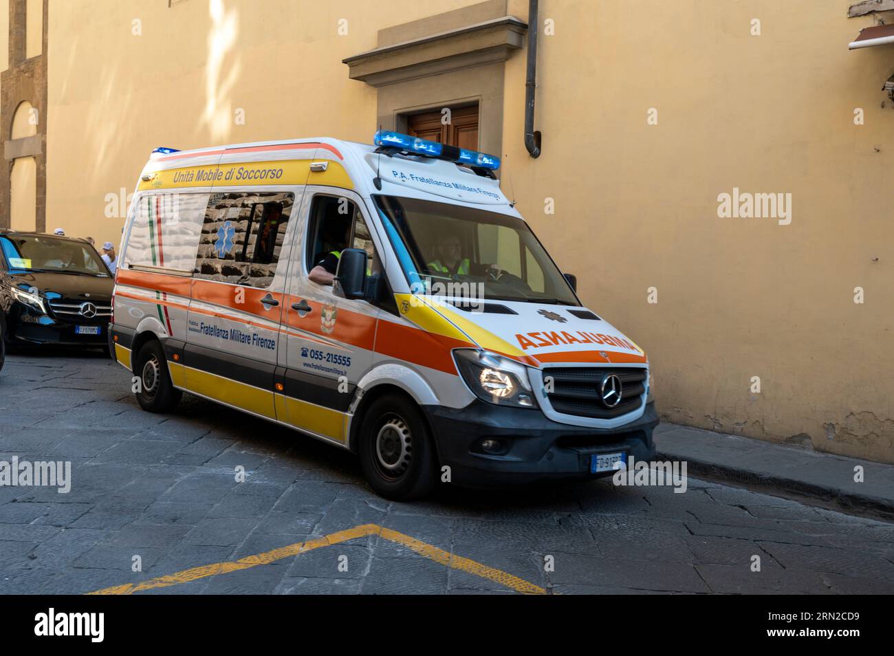 An ambulance on an emergency call speeds through the narrow medieval streets of Florence in the Tuscany region of Italy Stock Photo