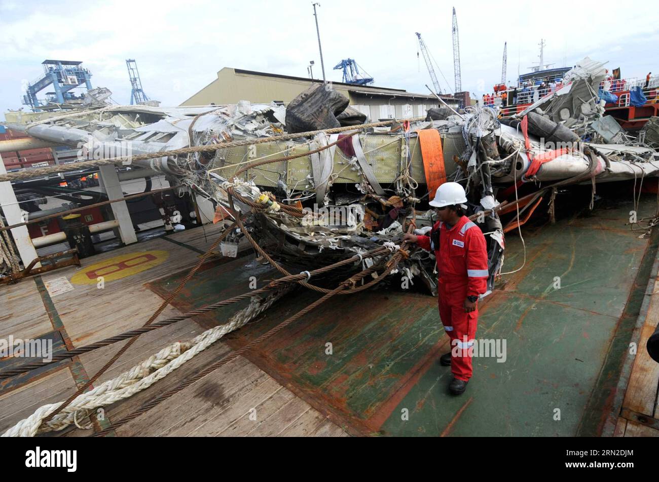 (150302) -- JAKARTA, March 2, 2015 -- An official checks a large part of AirAsia QZ 8501 fuselage at Tanjung Priok harbor in Jakarta, Indonesia, March 2, 2015. Indonesian officials said on Saturday that the final major part of the fuselage of the AirAsia QZ 8501 has been retrieved. AirAsia QZ 8501 was crashed in Karimata Strait enroute from Indonesia s city of Surabaya for Singapore on Dec. 28, killing all 162 people onboard. ) INDONESIA-JAKARTA-AIRASIA-PLANE-RETRIEVAL AgungxKuncahyaxB. PUBLICATIONxNOTxINxCHN   Jakarta March 2 2015 to Official Checks a Large Part of AirAsia  8501 fuselage AT T Stock Photo