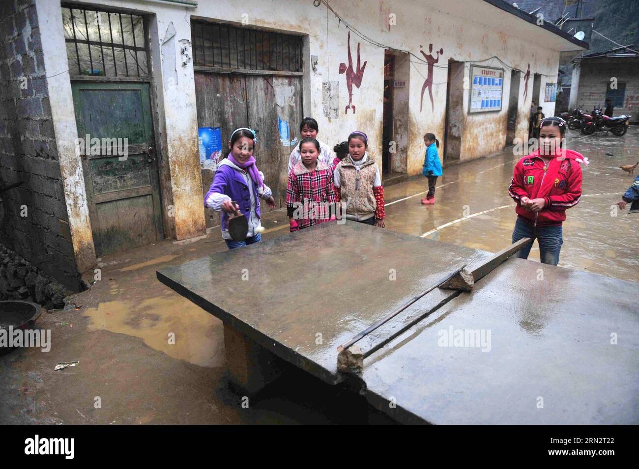 (150323) -- BANSHENG, March 23, 2015 -- Students play table tennis in front of their dormitory at Nongyong Primary School in Bansheng County, south China s Guangxi Zhuang Autonomous Region, Dec. 26, 2012. Nongyong Primary School was built in 1964. It is located in Bansheng County, a rural area of karst topography in Guangxi. Its initial school building consists of 12 one-storey houses. In 1990s, a two-storey teaching building and rough dormitory were built. There are about 250 students from all 22 villages of Nongyong. Every Monday, most of them have to walk over hills on their way to the scho Stock Photo