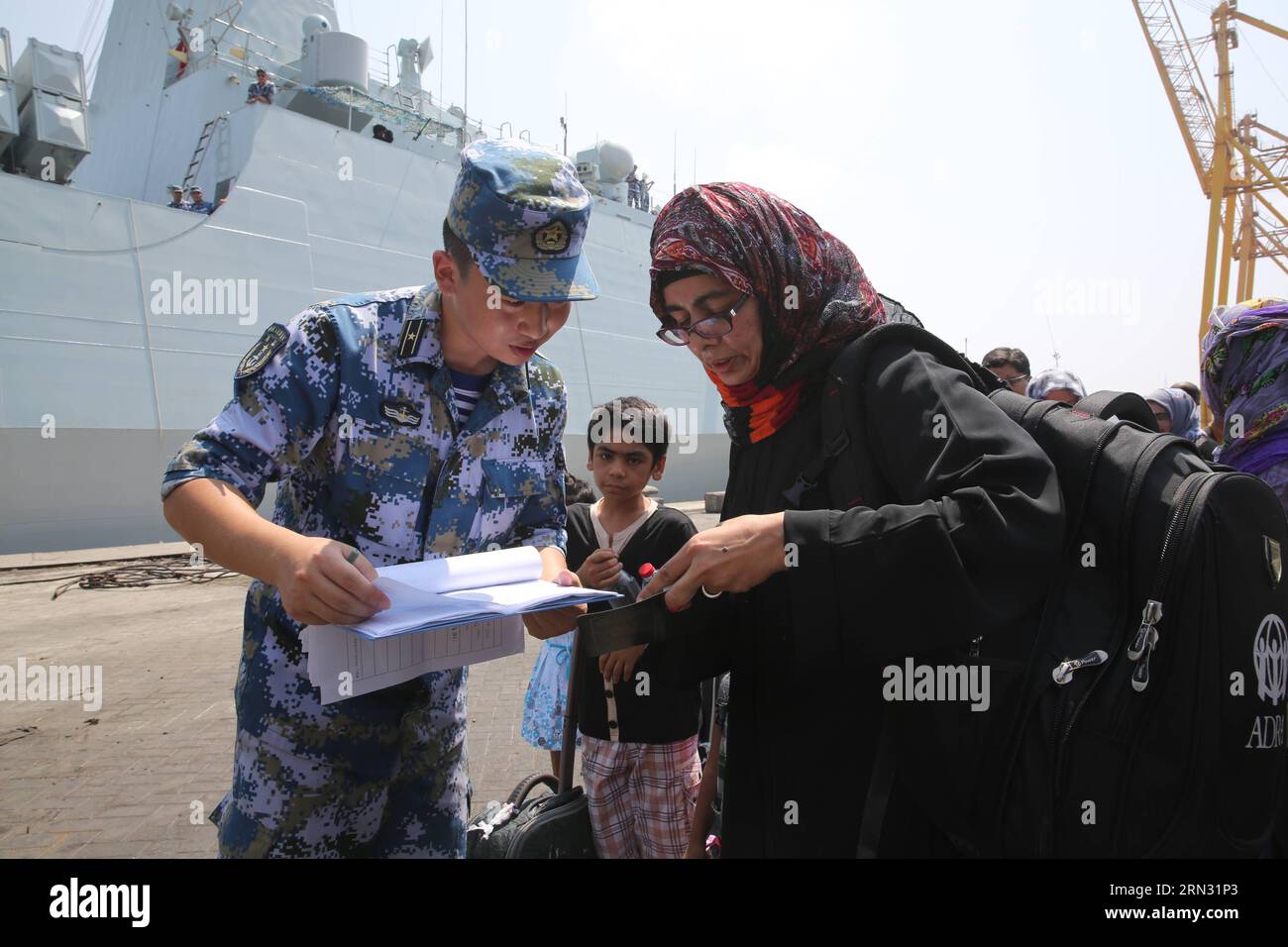 A crew member checks the passport of a woman before she board the Chinese Linyi missile frigate in Aden Harbor, Yemen, April 2, 2015. A total of 225 nationals from 10 countries who were evacuated from conflict-ridden Yemen arrived in Djibouti onboard a Chinese frigate on Thursday. ) (zcc) YEMEN-ADEN HARBOR-FOREIGNERS-WITHDRAW PanxSiwei PUBLICATIONxNOTxINxCHN   a Crew member Checks The Passport of a Woman Before She Board The Chinese Linyi Missile Frigate in Aden Harbor Yemen April 2 2015 a total of 225 Nationals from 10 Countries Who Were evacuated from CONFLICT  Yemen arrived in Djibouti Onbo Stock Photo