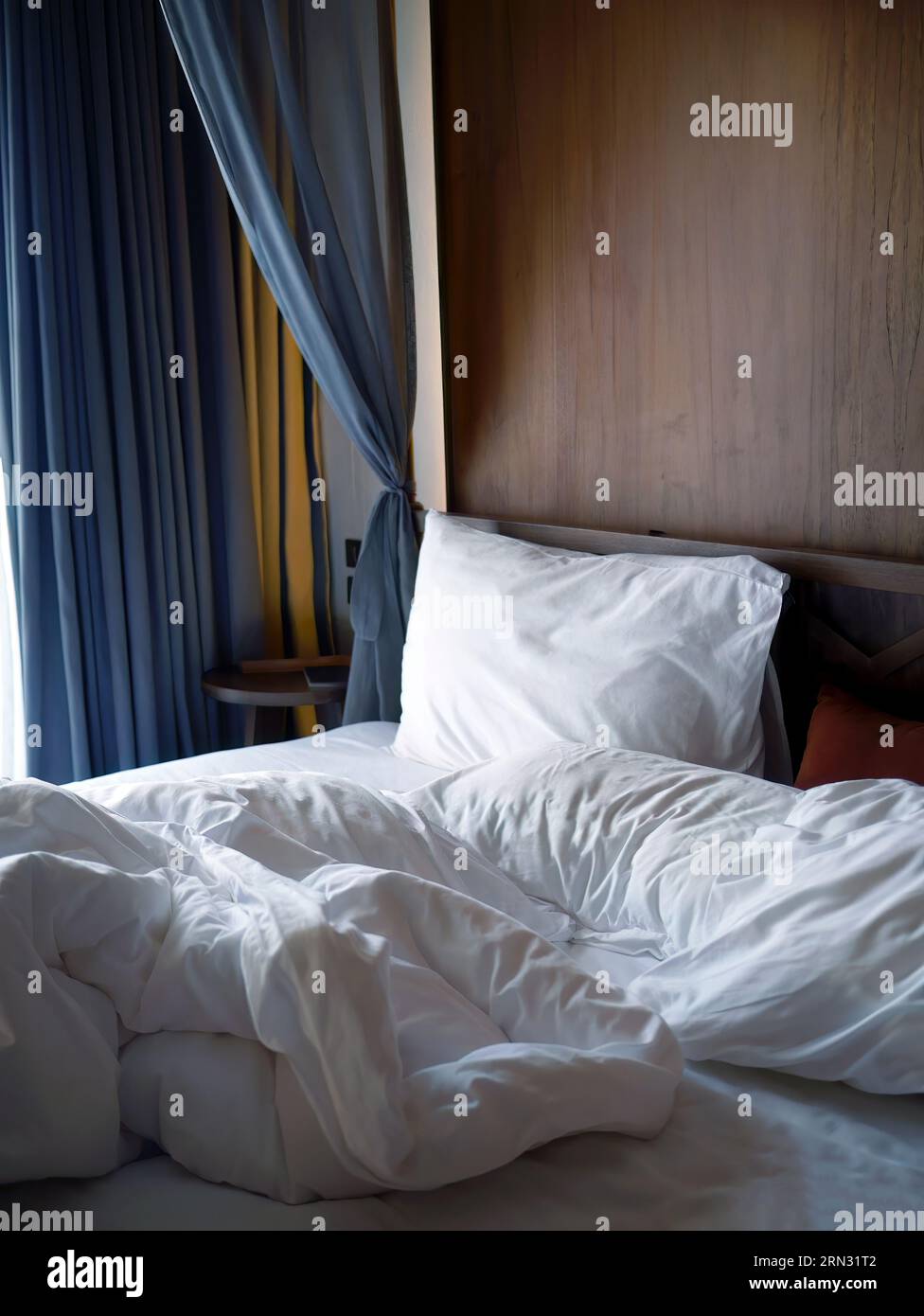 Crumpled white bedding sheets linen with pillow and blanket in soft morning lights, comfortable mood of rest and relax bedroom, unmade empty bed hotel Stock Photo