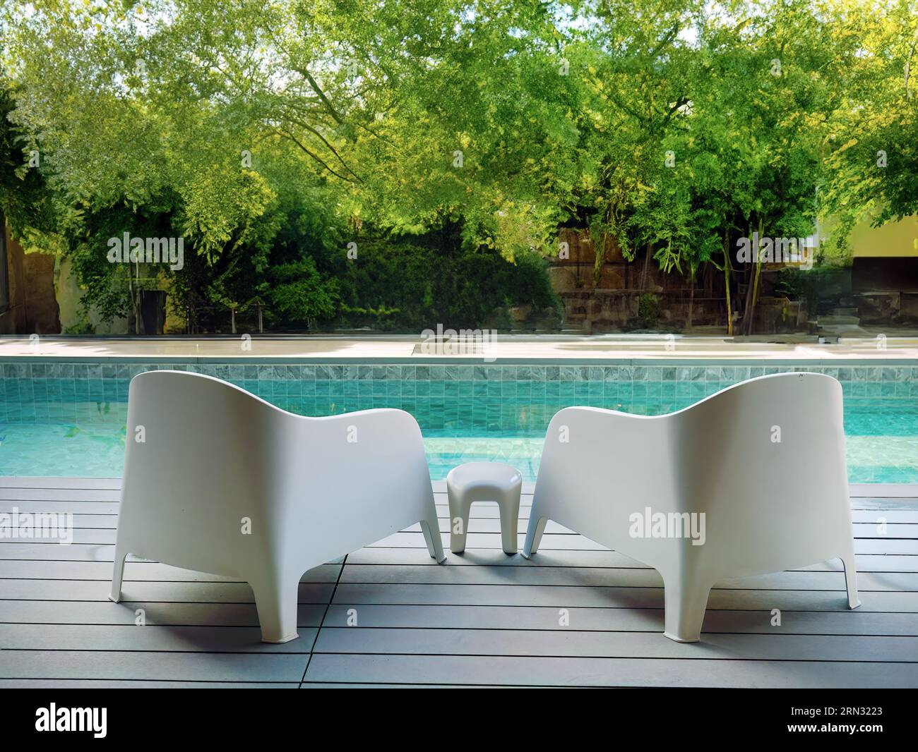 Modern design white plastic chairs at swimming pool side and outdoor garden, comfortable veranda decorated, wooden deck, back yard privacy space for r Stock Photo