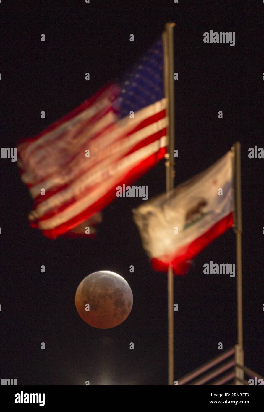 (150404) -- LOS ANGELES, April 4, 2015 -- The moon, with an orange hue that gives it the famous name blood moon , is seen behind the flags of U.S. and California State at Santa Monica Beach in Santa Monica, California, during a total lunar eclipse on April 4, 2015. According to astronomical data, the eclipse is the shortest one since the 21st century as the totality lasted only for 12 minutes. ) U.S.-LOS ANGELES-ECLIPSE ZhaoxHanrong PUBLICATIONxNOTxINxCHN   Los Angeles April 4 2015 The Moon With to Orange Hue Thatcher Gives IT The Famous Name Blood Moon IS Lakes behind The Flags of U S and Cal Stock Photo
