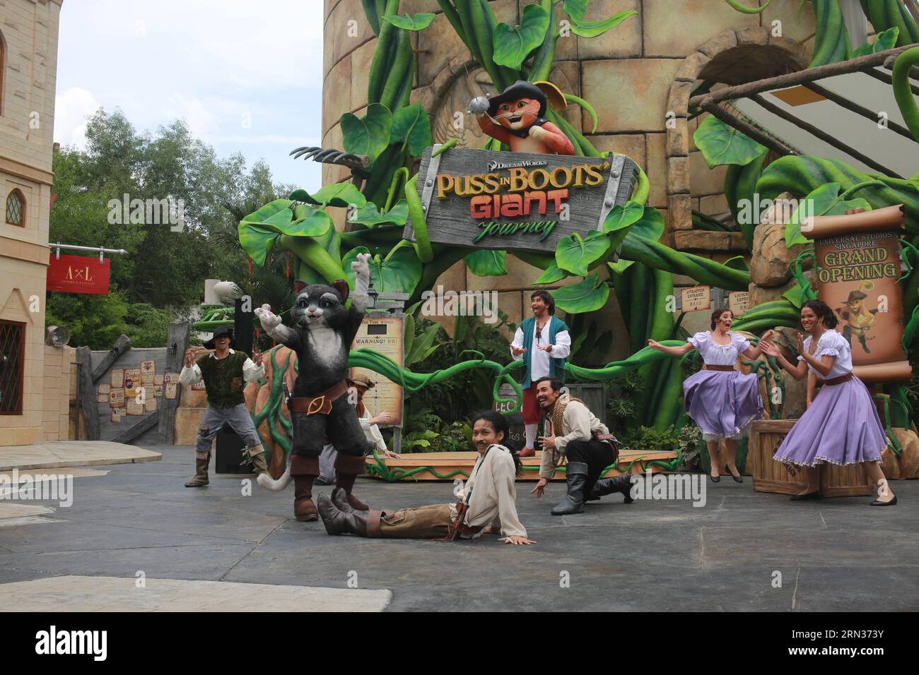 (150408) -- SINGAPORE, April 8, 2015 -- Actors perform in front of the entrance of Puss In Boots Giant Journey roller coaster at Universal Studios Singapore in Singapore, on April 8, 2015. Puss In Boots Giant Journey , a suspended roller coaster program, was launched on Wednesday at Universal Studios Singapore. Puss In Boots , who originally appeared in the Shrek franchise, rose to stand-alone fame in October 2011 with his first hit movie. The launch of the themed suspended roller coaster highlights the theme park s fifth anniversary celebrations. ) SINGAPORE-UNIVERSAL STUDIOS SINGAPORE- PUSS Stock Photo