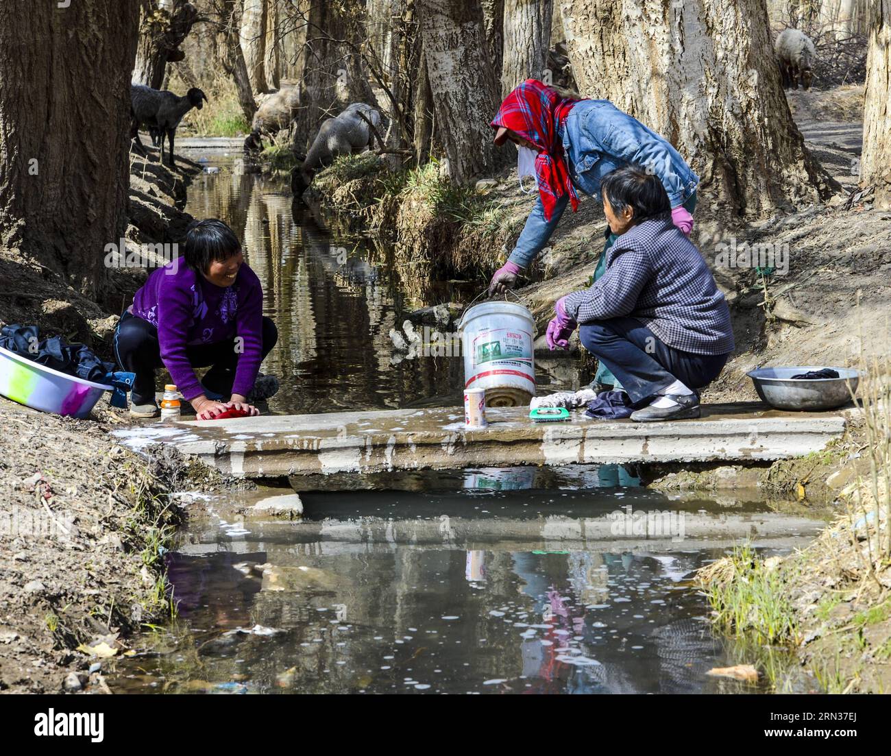 TURPAN, 2015 People wash clothes in a canal beside a karez well in