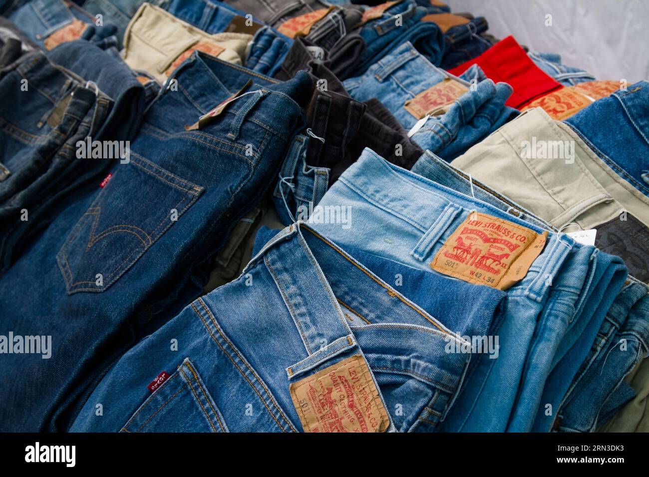 Folded Vintage Levis Strauss Denim Jeans For Sale On A Vintage Clothing Market Stall, England, Uk Stock Photo
