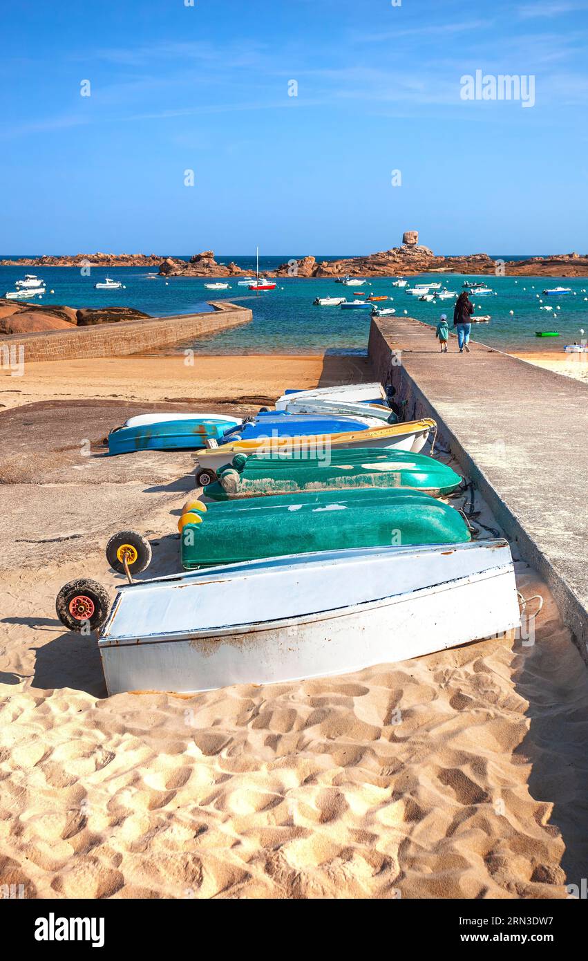 France, Cotes d'Armor, Tregastel, Perros Guirec, upturned boats near the slipway of Coz Pors, with the Rocher du De in the background Stock Photo