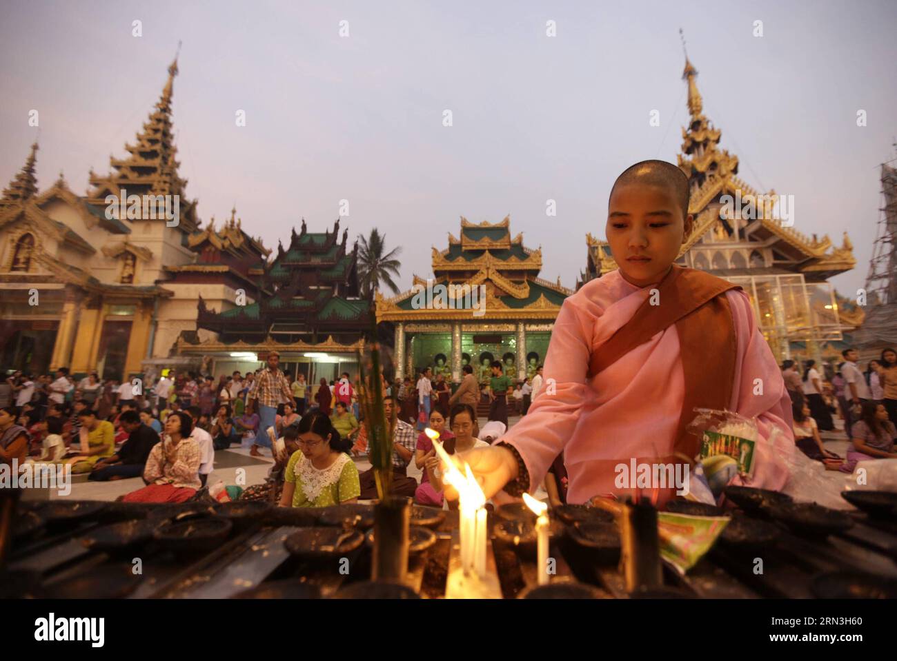 (150417) -- YANGON, April 17, 2015 -- A nun lights candles on the first day of Myanmar s new year at the world-famous Shwedagon Pagoda in Yangon, Myanmar, April 17, 2015. On the first day of Myanmar s new year, people in the country used to perform meritorious deeds and Buddhists, who account for the majority of the people, usually go to the pagodas, monasteries and meditation centers where they practice meditation. ) MYANMAR-YANGON-NEW YEAR UxAung PUBLICATIONxNOTxINxCHN   Yangon April 17 2015 a now Lights Candles ON The First Day of Myanmar S New Year AT The World Famous Shwedagon Pagoda in Y Stock Photo