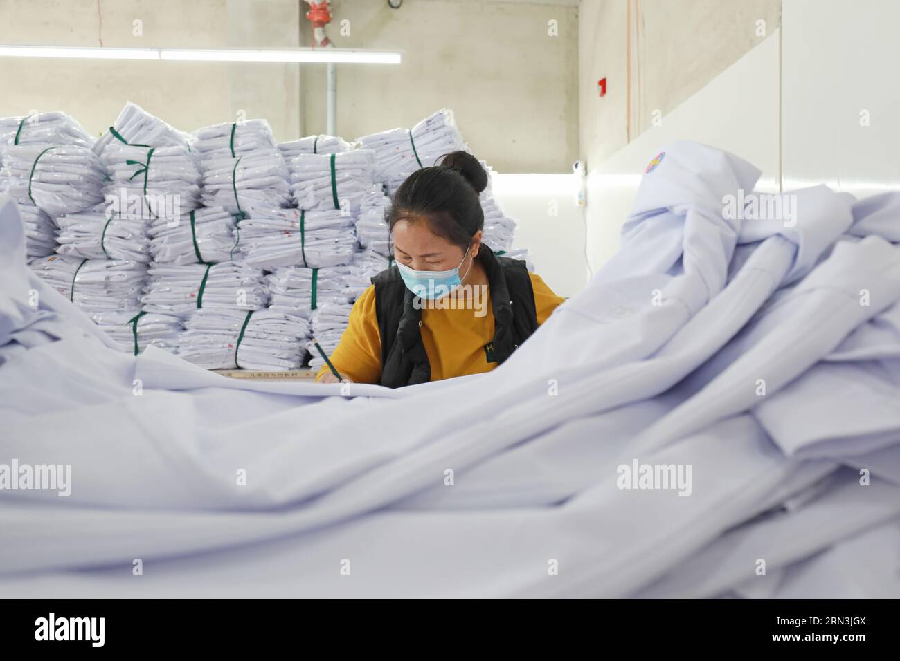 LUANNAN COUNTY, Hebei Province, China - April 8, 2020: The workers are busy on the production line in a garment factory. Stock Photo