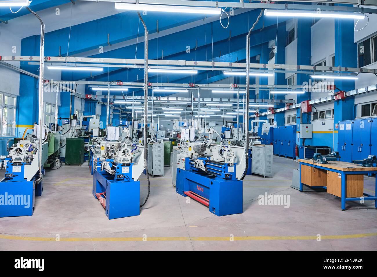 many identical industrial machinery in a row at a factory. equipment of a factory/workshop. high-tech factory machines. automatized workshop Stock Photo