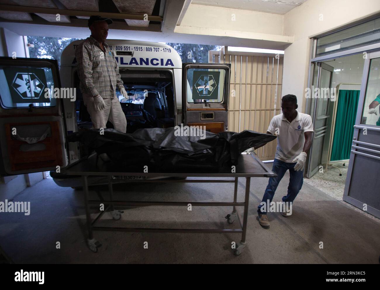 (150421) -- SANTO DOMINGO, April 20, 2015 -- People move the bodies of the victims of a plane accident, in the Pathology Center of the Cristo Redentor Cementery, in Santo Domingo, Dominican Republic, on April 20, 2015. Four Spanish and two British tourists died in the accident of a plane that occurred on Monday in Dominican Republic, local authorities confirmed. The accident happened after 08:00, local hour, when the type PA-32 plane, registration number HI-957, precipitated to the ground and caught fire, close to a residential zone of the touristic locality of Punta Cana, leaving no survivors Stock Photo