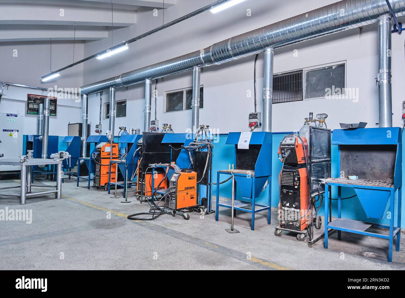 many identical industrial machinery in a row at a factory. equipment of a factory/workshop. high-tech factory machines. automatized workshop Stock Photo