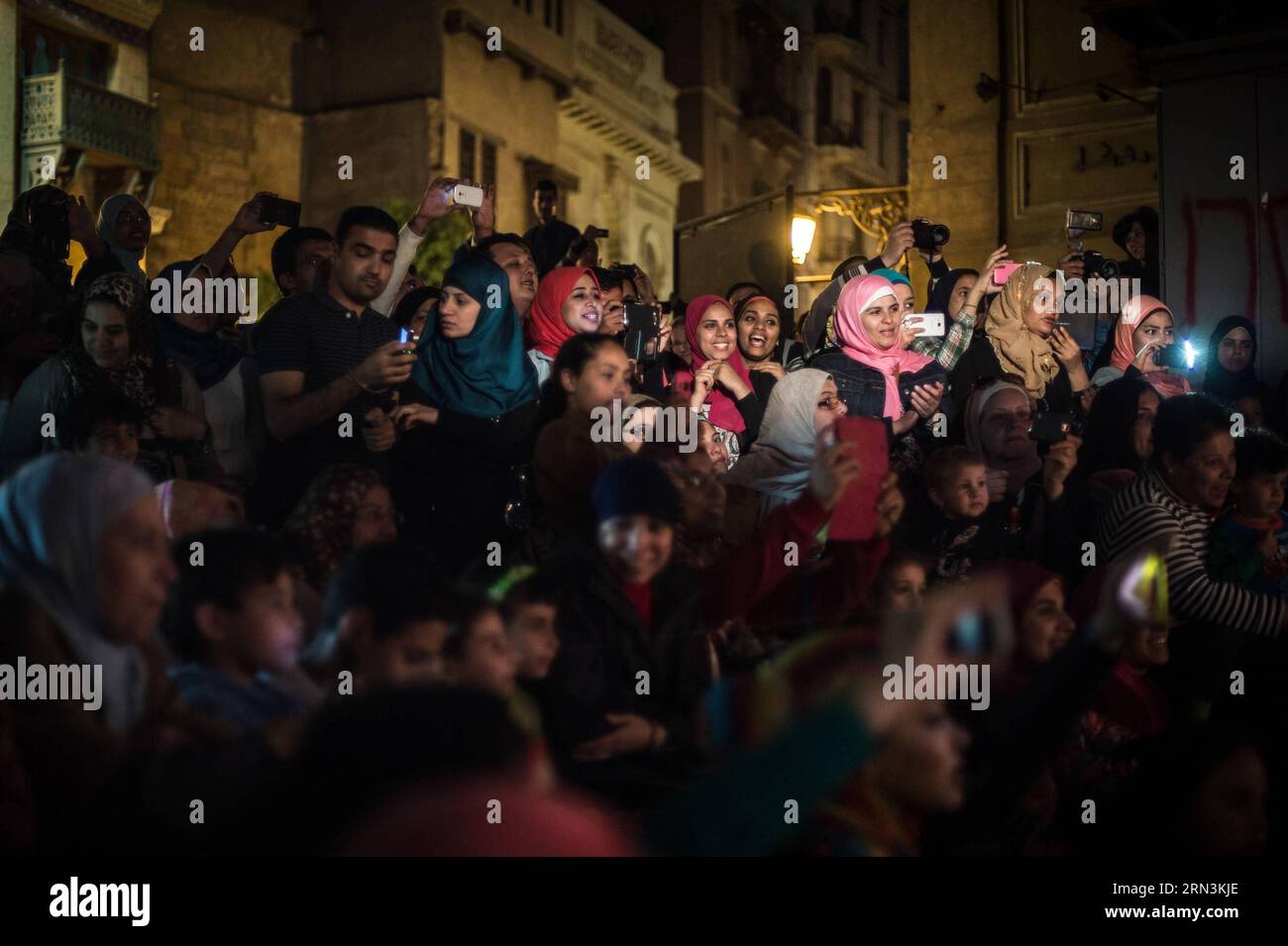 (150421) -- CAIRO, April 21, 2015 -- Audience reacts during an open-air show for World Heritage Day in the old town of Cairo, Egypt, on April 18, 2015. Puppetry has a long history in Egypt, which could be dated back to the Pharaonic times. Egyptians began to manufacture Marionette dolls for entertainment in the 1960 s, when they established the National Puppet Theatre in capital Cairo. Due to social turmoil, entertainments seem rare and precious for Egyptian people. Meanwhile the fading industry of puppetry is challenged by mass media, internet and mobile phones and gradually lost popularity i Stock Photo