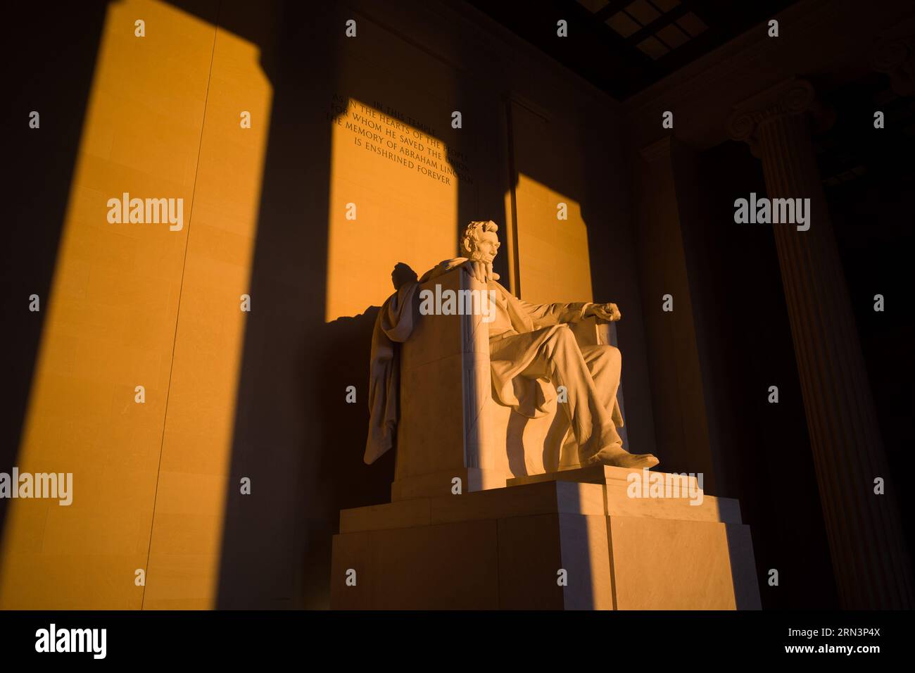 WASHINGTON DC, United States — The Lincoln Memorial statue, illuminated by the golden light of sunrise during the spring solstice, casts a warm glow over the historic monument. This specific solar event accentuates the features of the iconic tribute to America's 16th president, emphasizing Abraham Lincoln's role in the nation's history. Stock Photo