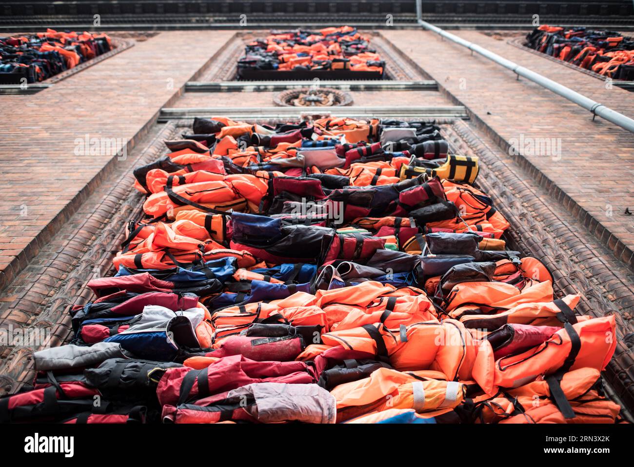 COPENHAGEN, Denmark — A large art installation by Ai Weiwei titled Soleil Levant on the facade of Kunsthal Charlottenborg on the waterfront of Copenhagen's harbor. The piece consists of a barricade of the building's windows with more than 3500 life jackets collected from refugees on the Greek island of Lesbos. It was unveiled on UN International Refugee Day on June 20, 2017, and remained in place until the beginning of October 2017. Kunsthal Charlottenborg is the official exhibition gallery of the Royal Danish Academy of Art. Stock Photo