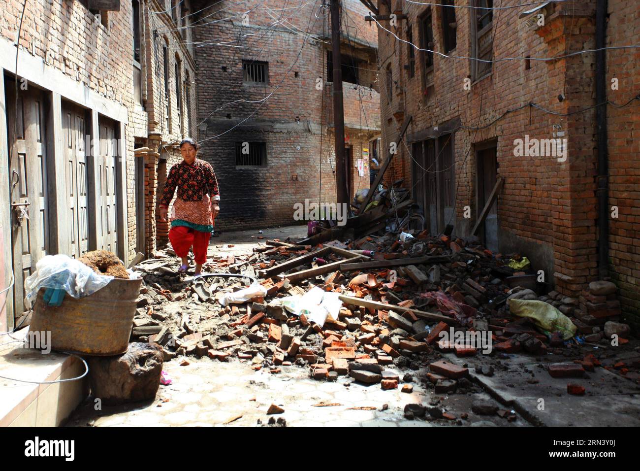 (150429) -- LALITPUR, April 29, 2015 -- A woman walks past debris after earthquake in Lalitpur, Nepal, April 29, 2015. The 7.9-magnitude quake hit Nepal at midday on Saturday. The death toll from the powerful earthquake has soared to 5,057 and a total of 10,915 others were injured. )(bxq) NEPAL-LALITPUR-EARTHQUAKE-AFTERMATH SunilxSharma PUBLICATIONxNOTxINxCHN   Lalitpur April 29 2015 a Woman Walks Past debris After Earthquake in Lalitpur Nepal April 29 2015 The 7 9 magnitude Quake Hit Nepal AT midday ON Saturday The Death toll from The Powerful Earthquake has soared to 5  and a total of 10 915 Stock Photo