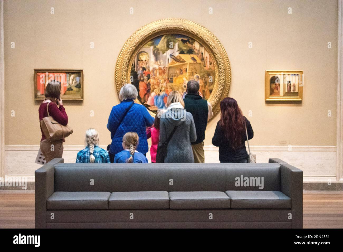 WASHINGTON, D.C., United States — Visitors admire Fra Angelico and Filippo Lippi's 'Adoration of the Magi' (c.1440-1460) at the National Gallery of Art. This Renaissance masterpiece draws art enthusiasts to contemplate its intricate details and religious significance. Stock Photo