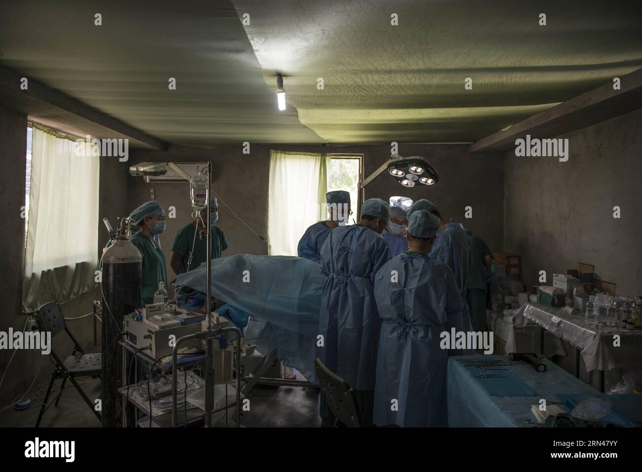 Doctors and nurses of emergency department of China s Chengdu Military Region Medical Team perform a surgery in an operating room at a field hospital in Kathmandu, Nepal, May 10, 2015. Since the arrival, the Chengdu Military Region Medical Team, the only foreign aid team capable of performing full-spectrum bone- related surgical operations, has treated over 200 patients, conducted more than 100 surgical operations, including 34 major ones. The team has also provided psychological counseling to nearly 500 people, and has disinfected a total area of over 850,000 square meters. In contrast to the Stock Photo