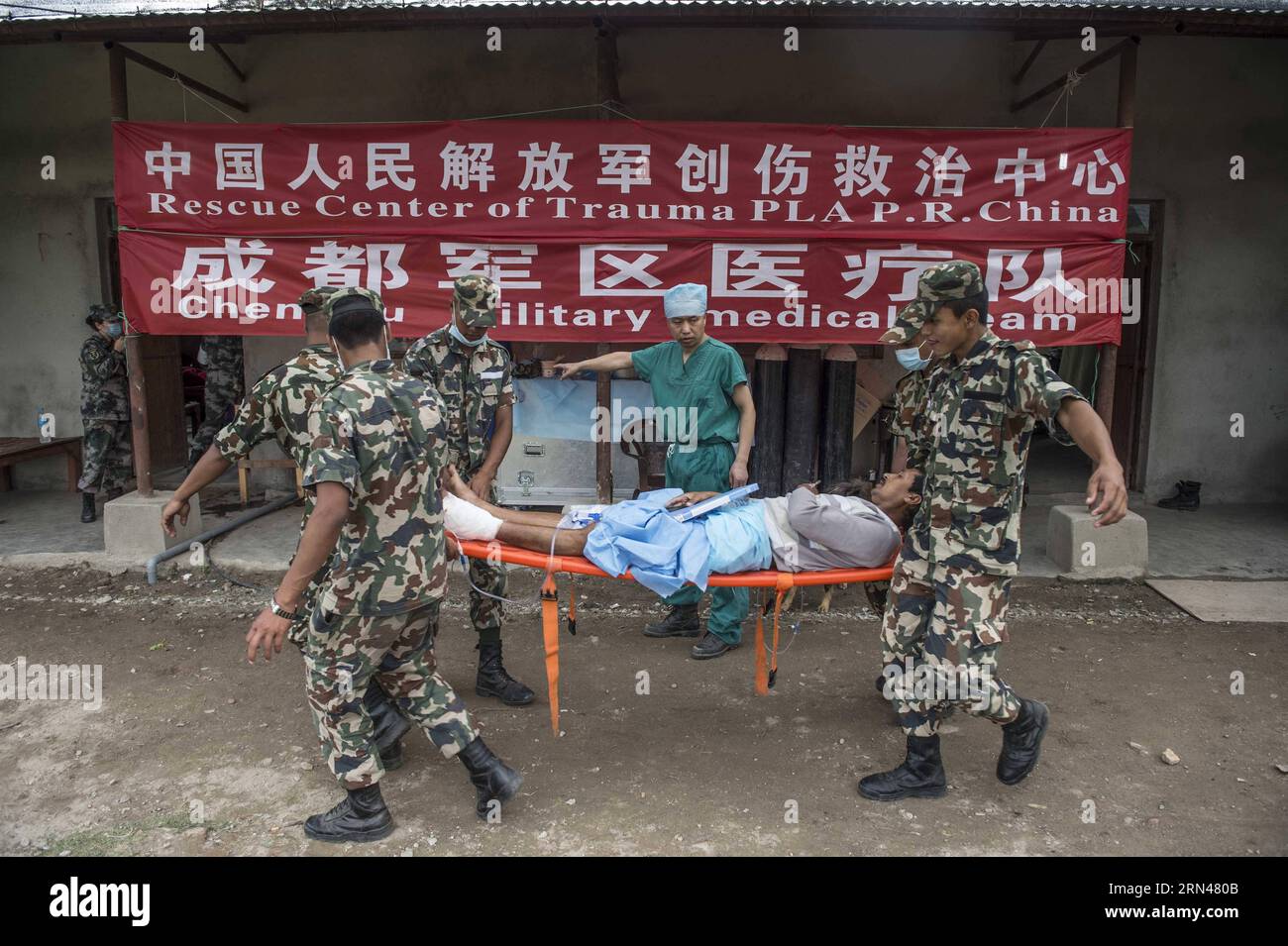 Members of China s Chengdu Military Region Medical Team transfer a patient to the intensive care unit after performing a surgery in Kathmandu, Nepal, May 10, 2015. Since the arrival, the Chengdu Military Region Medical Team, the only foreign aid team capable of performing full-spectrum bone- related surgical operations, has treated over 200 patients, conducted more than 100 surgical operations, including 34 major ones. The team has also provided psychological counseling to nearly 500 people, and has disinfected a total area of over 850,000 square meters. In contrast to their typical Internatio Stock Photo