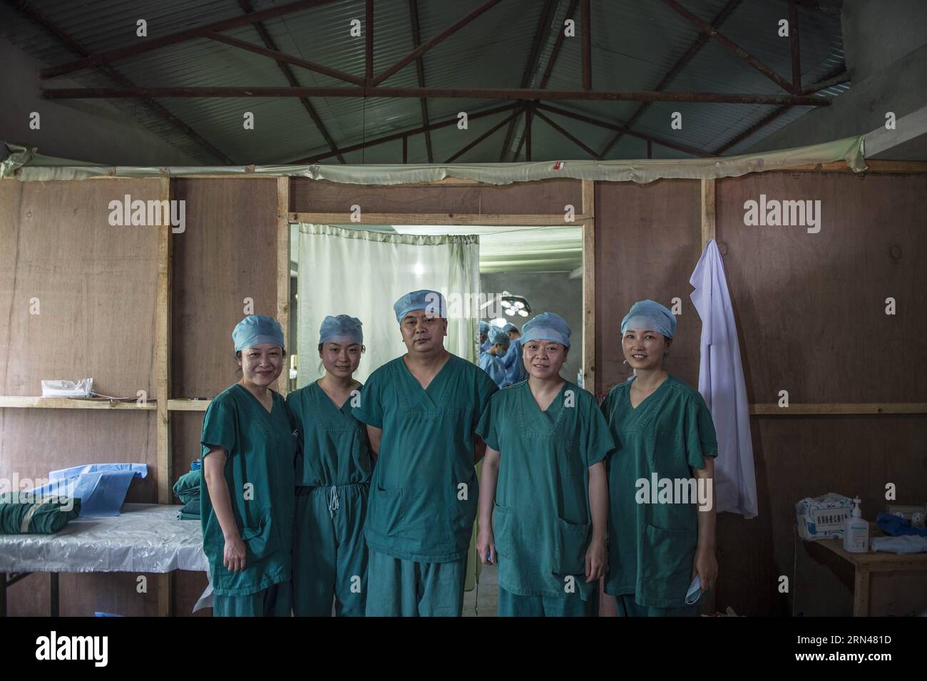 Members of emergency department of China s Chengdu Military Region Medical Team pose for a group photo outside the door of an operating room in Kathmandu, Nepal, May 10, 2015. Since the arrival, the Chengdu Military Region Medical Team, the only foreign aid team capable of performing full-spectrum bone- related surgical operations, has treated over 200 patients, conducted more than 100 surgical operations, including 34 major ones. The team has also provided psychological counseling to nearly 500 people, and has disinfected a total area of over 850,000 square meters. In contrast to their typica Stock Photo