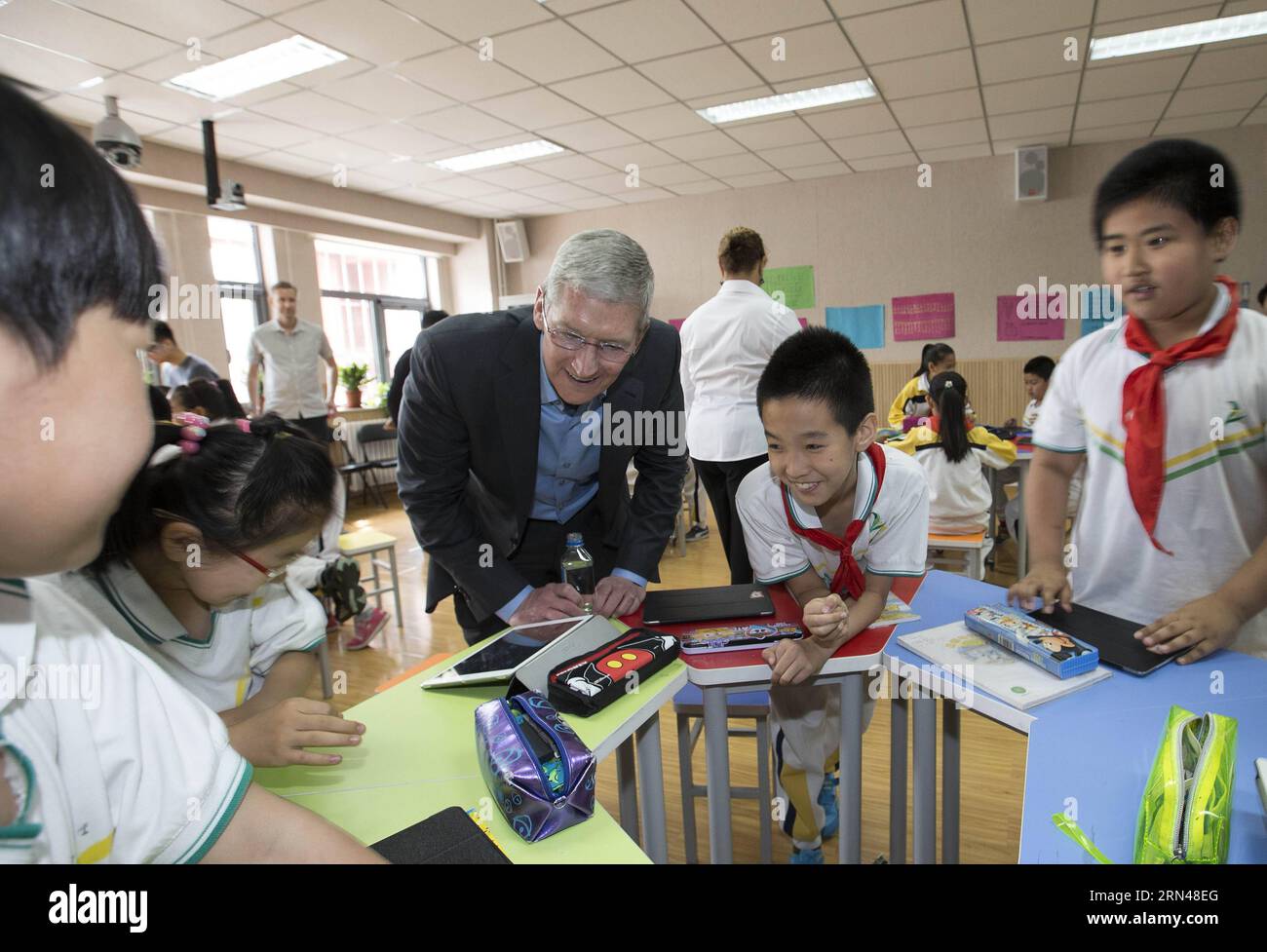 (150512) -- BEIJING, May 12, 2015 -- Tim Cook, CEO of Apple Inc., interacts with students during a lesson at the Primary School attached to Communication University of China in Beijing, capital of China, May 12, 2015. Tim Cook visited the Primary School attached to Communication University of China on Tuesday. ) (yxb) CHINA-BEIJING-APPLE CEO-PRIMARY SCHOOL-VISIT(CN) LixMing PUBLICATIONxNOTxINxCHN   150512 Beijing May 12 2015 Tim Cook CEO of Apple INC interact With Students during a Lesson AT The Primary School Attached to Communication University of China in Beijing Capital of China May 12 201 Stock Photo