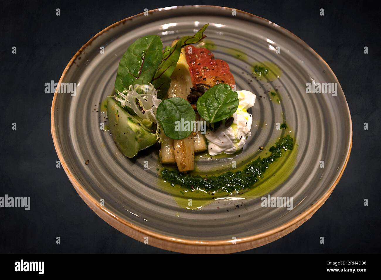 Starter plate with asparagus, lettuce, feta cheese and tomatoes on a dark background, Baden-Wuerttemberg, Germany Stock Photo