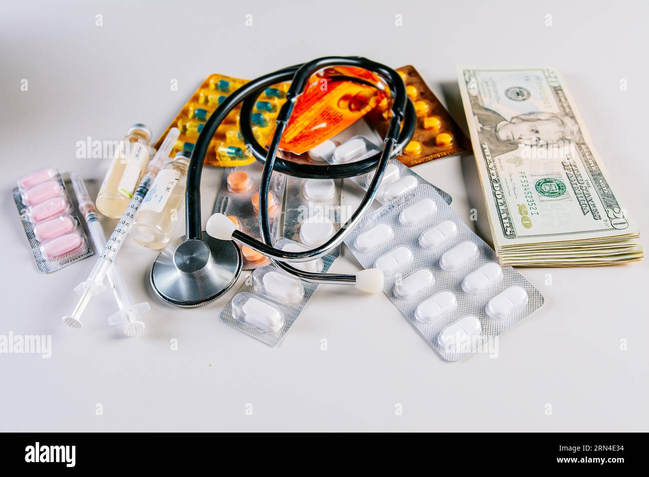 Concept of medicine, stethoscope, money and drug addiction. Medical stethoscope with medicaments on money Stock Photo