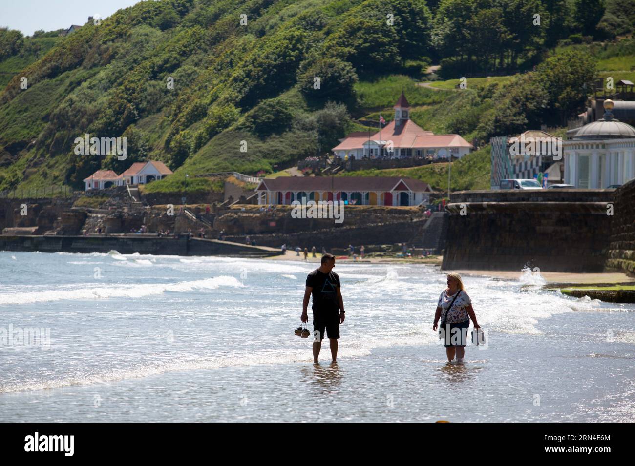 People stroll in the water in Scarborough, north Yorkshire. The water quality in Scarborough is poor due to the impact of sewage being discharged into Stock Photo