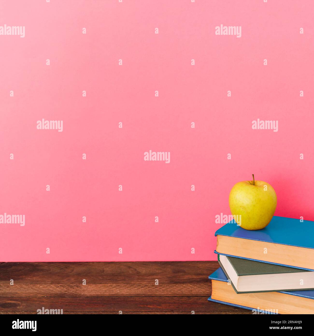 Apple books near pink wall Stock Photo