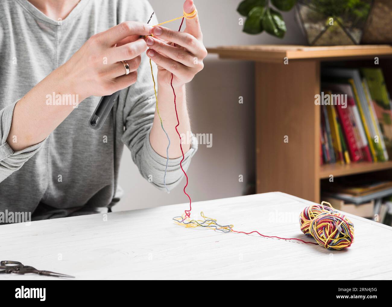 Female hands knitting with colorful thread Stock Photo