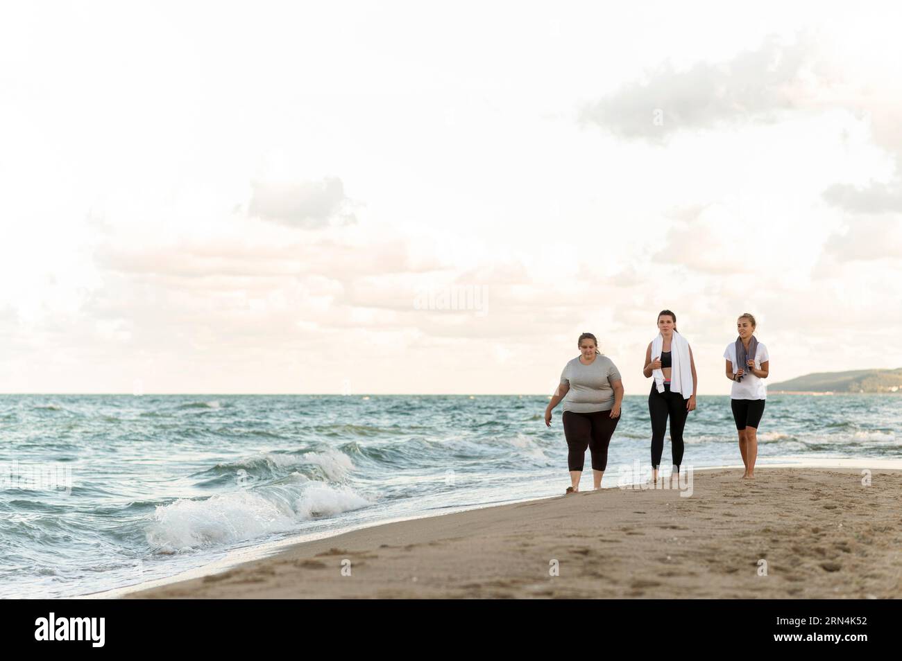 Long shot fitness friends walking shore Stock Photo