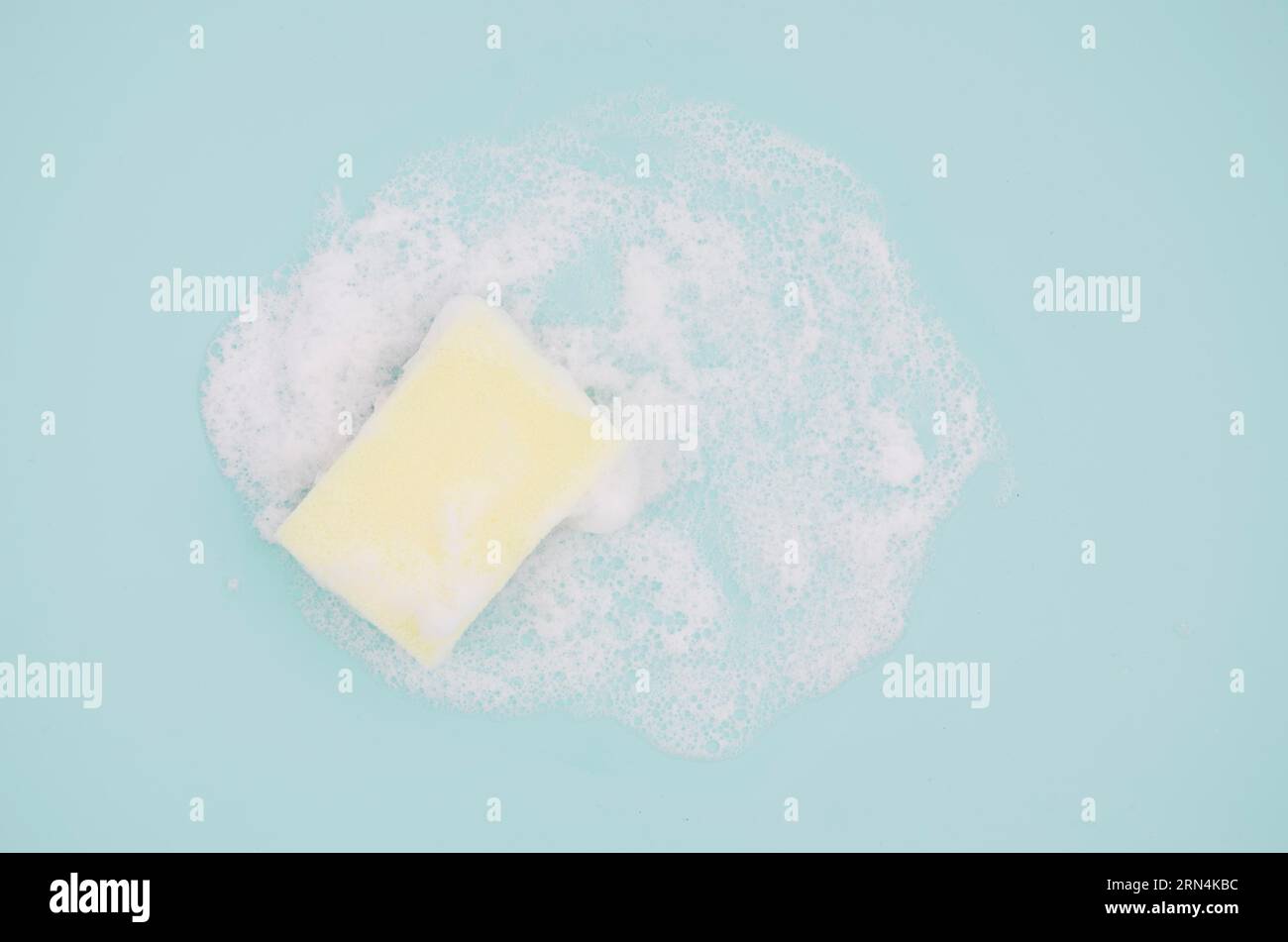 Overhead view sponge with sud blue background Stock Photo