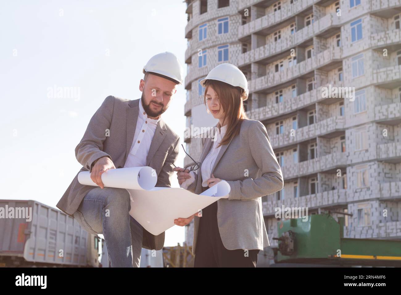 Two architects holding blueprint discussing project while working together Stock Photo