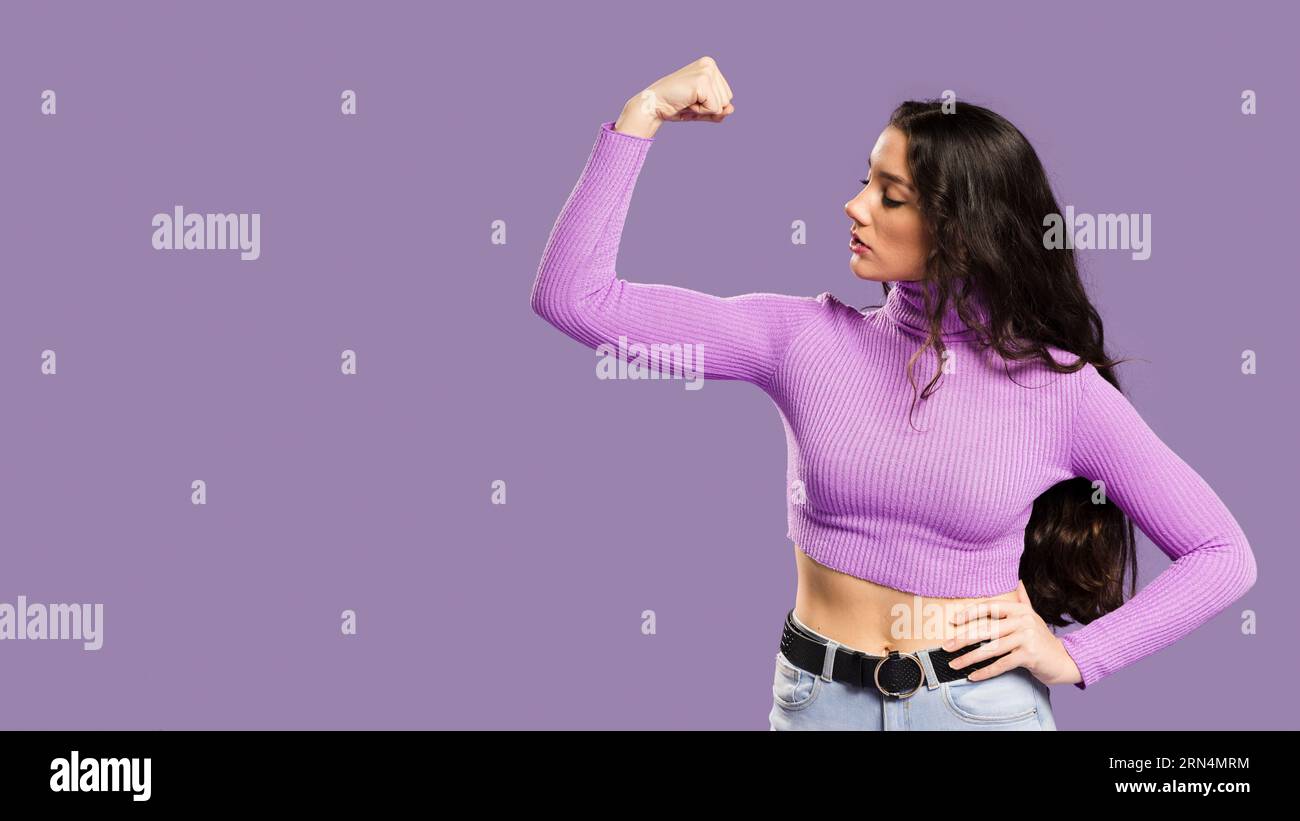 Woman showing muscles having violet top sideways Stock Photo