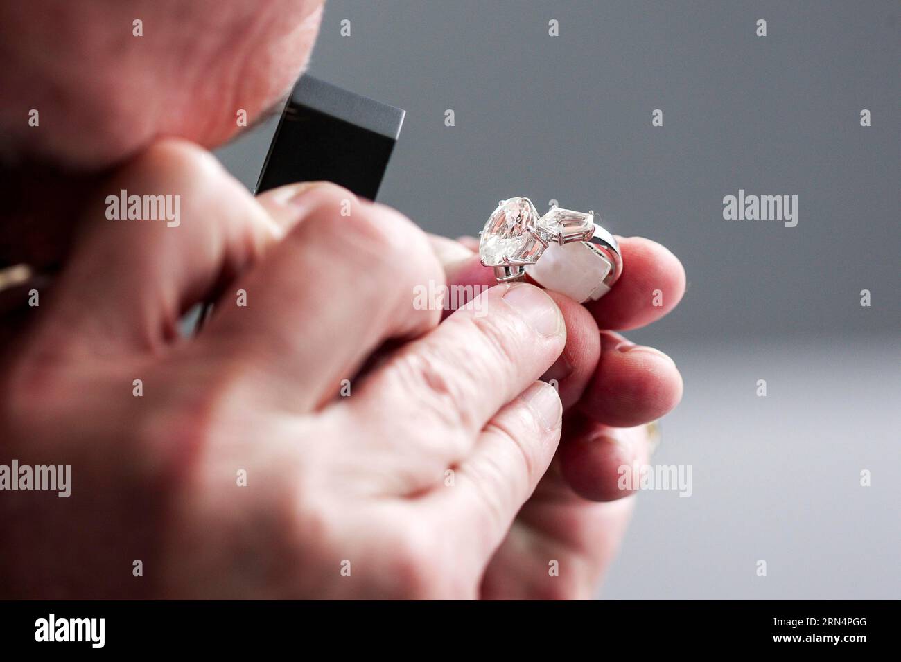 Checking a ring with a gemstone for authenticity Stock Photo