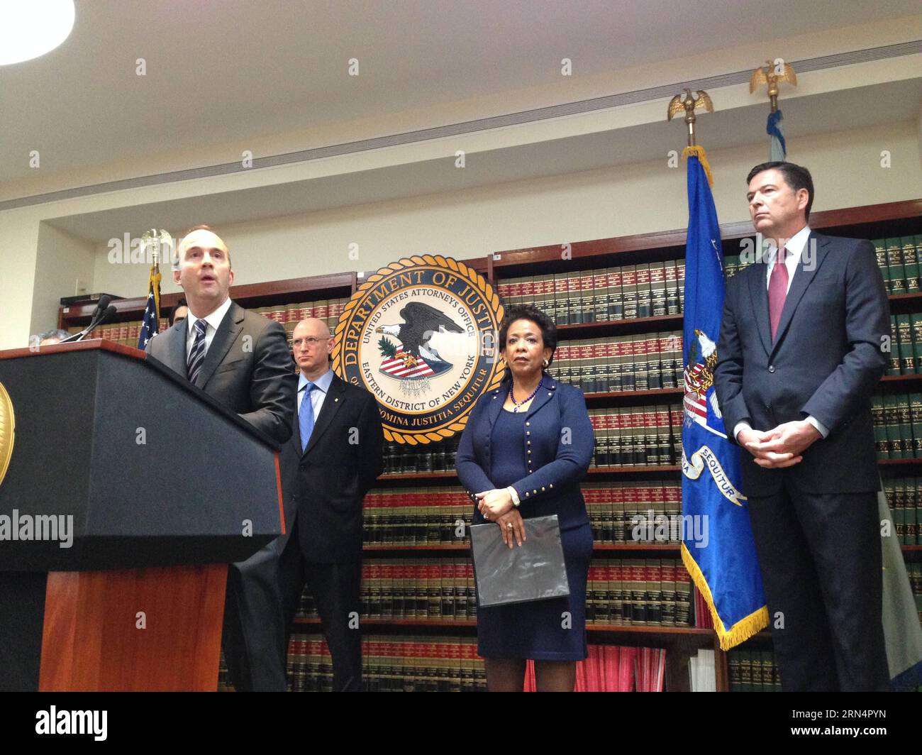 (150527) -- NEW YORK, May 27, 2015 -- Photo taken by a mobile phone shows U.S. Attorney General Loretta Lynch(2nd R), Richard Weber(2nd L), Chief of the Internal Revenue Service-Criminal Investigation, FBI Director James B. Comey(1st R) and Acting U.S. Attorney Kelly Currie of the Eastern District of New York attending a press conference in New York, the United States, on May 27, 2015. 14 defendants including high- ranking officials of the FIFA were charged Wednesday by U.S. Department of Justice with racketeering, wire fraud and money laundering conspiracies, enriching themselves through the Stock Photo