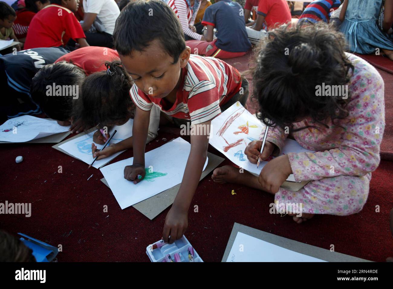 (150528) -- KATHMANDU, May 28, 2015 -- Children participate in a drawing class at a temporary shelter at Tundikhel in Kathmandu, capital of Nepal, on May 28, 2015. Shanti Education Initiative Nepal organized an art and craft program to help the quake-affected children to get out from quake trauma. ) NEPAL-KATHMANDU-EARTHQUAKE-AFTERMATH-CHILDREN PratapxThapa PUBLICATIONxNOTxINxCHN   150528 Kathmandu May 28 2015 Children participate in a drawing Class AT a temporary Shelter AT Tundikhel in Kathmandu Capital of Nepal ON May 28 2015 Shanti Education Initiative Nepal Organized to Art and Craft Prog Stock Photo