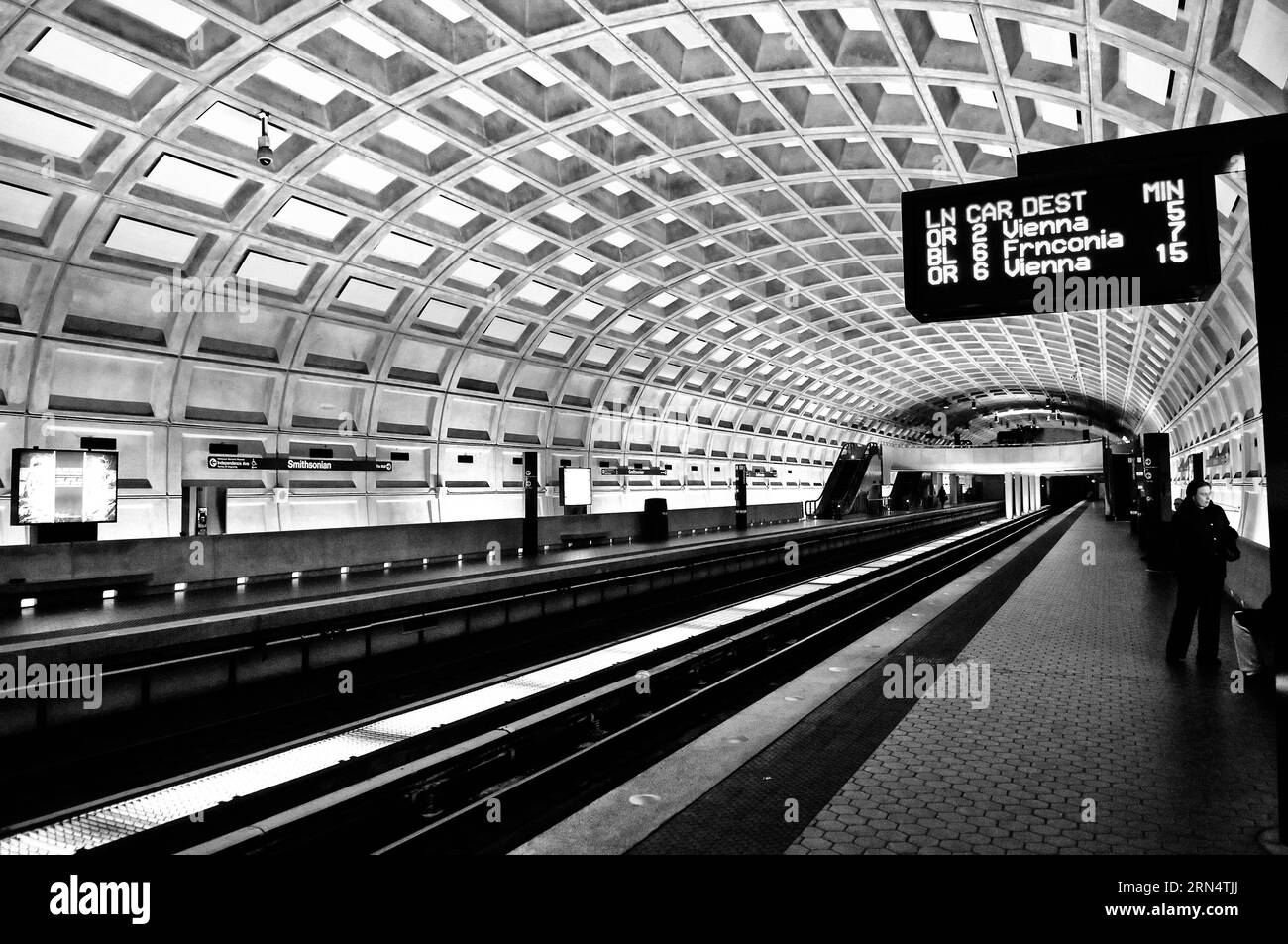 Vaulted ceiling, Smithsonian station, Washington, D.C. Black and white photograph showing the coffered ceiling, platform, and train tracks receding into the distance. Stock Photo