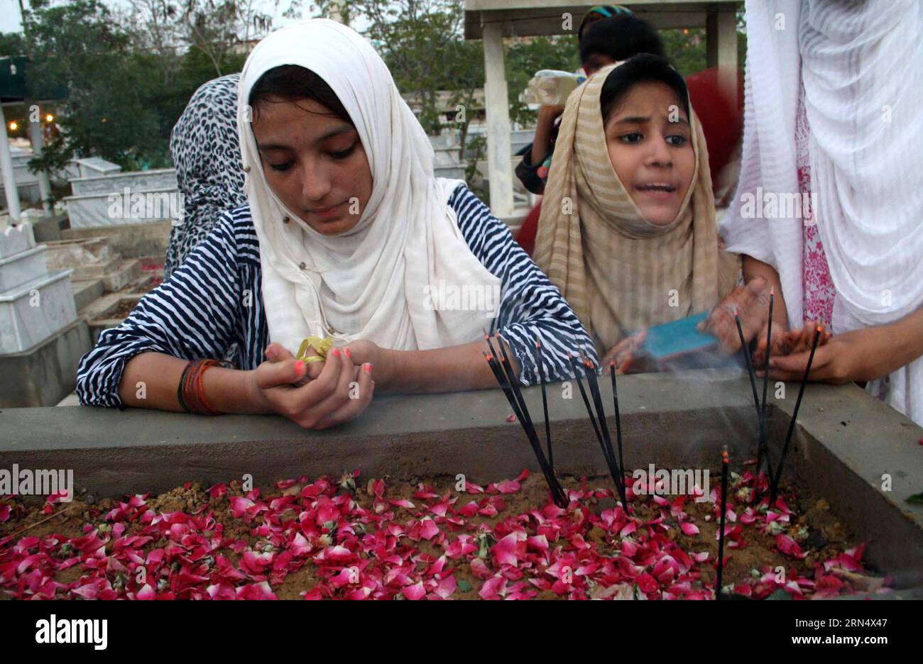 KARACHI, June 2, 2015 -- Pakistani Muslim women pray around graves of their relatives to mark Shab-e-Barat, or the night of forgiveness, in southern Pakistani port city of Karachi, June 2, 2015. Muslims believe that if someone prays to God throughout the night and seeks forgiveness for all the sins he may have committed, he could be forgiven. The entire night of prayer is devoted to asking for forgiveness for the past year and for good fortune in the year to come. ) PAKISTAN-KARACHI-SHAB-E-BARAT-MUSLIM FESTIVAL Masroor PUBLICATIONxNOTxINxCHN   Karachi June 2 2015 Pakistani Muslim Women Pray Ar Stock Photo